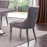 A close-up view of the Plato Velvet Fabric Dining Chair in elegant grey, accentuated by stainless steel legs and a distinctive lion head knocker on the back, embodying opulence and regal charm