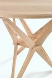 Close-up of the star-shaped base design featuring three X-frames in light Sungkai wood