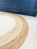 Durable jute-based round rug with soft cotton surface, featuring a captivating braided texture